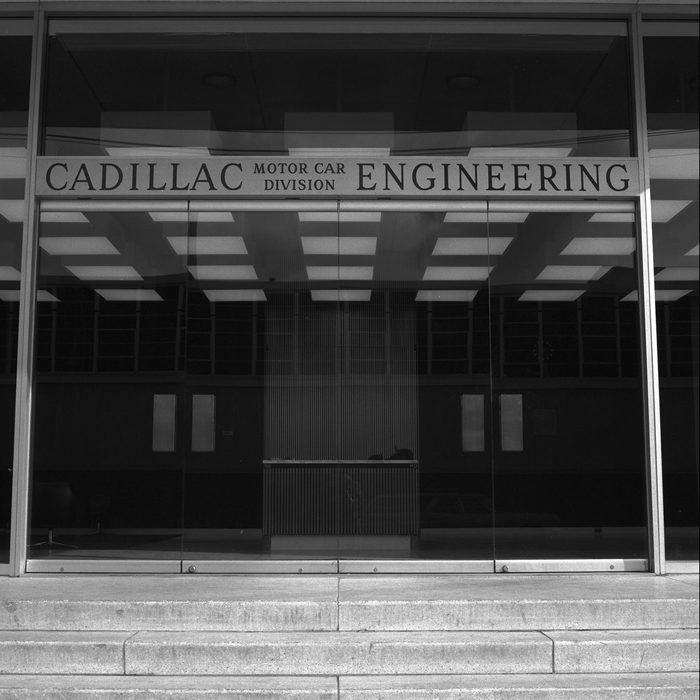 Black-and-white photograph of the Cadillac Motor Car Division Engineering glass entrance and overhead signage