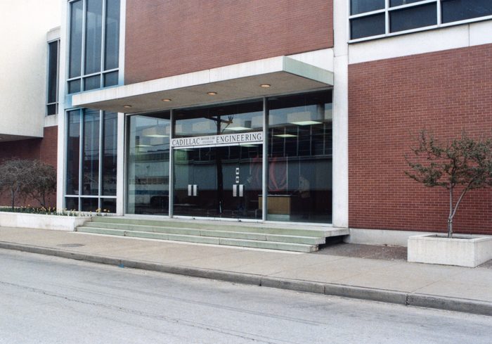 Color photograph of the full Cadillac Engineering entrance and red-brick building along Scotten Street